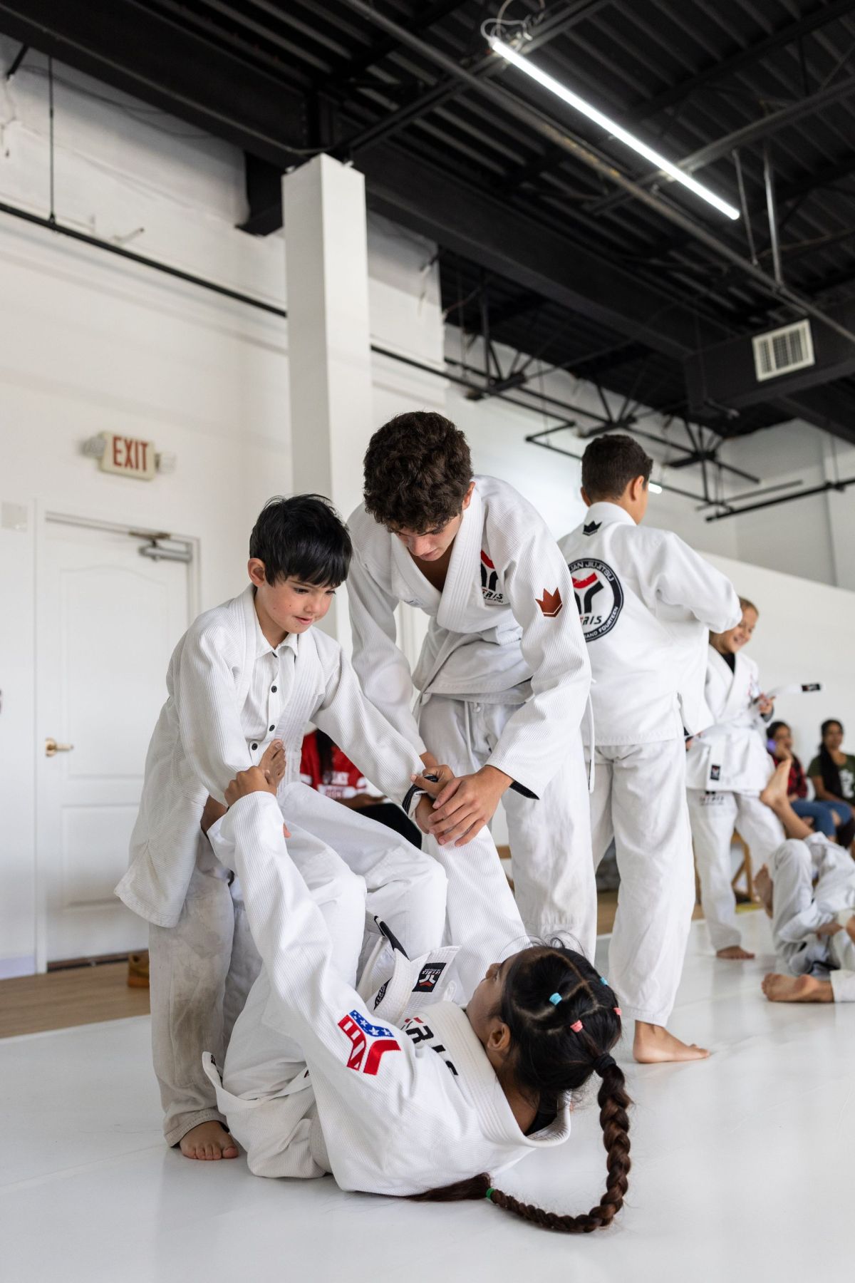 Kids learning Jiu-Jitsu with a coach